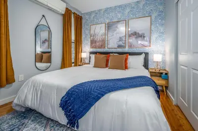 a bedroom with a large bed with a blue wall at Prime OTR by TQL, Smart TVs, King Bed, Wifi, Sleeps 3ppl, 1st Fl in Cincinnati