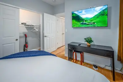 a bedroom with a bed and a tv on the wall at Prime OTR by TQL, Smart TVs, King Bed, Wifi, Sleeps 3ppl, 1st Fl in Cincinnati