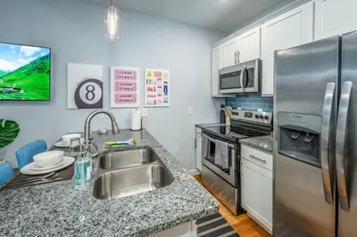 a kitchen with a sink and a stainless steel refrigerator at Prime OTR by TQL, Smart TVs, King Bed, Wifi, Sleeps 3ppl, 1st Fl in Cincinnati