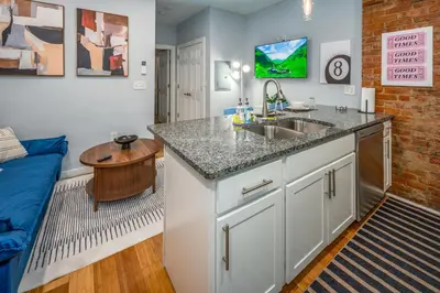 a kitchen with a sink and a living room with a couch at OTR by TQL, Smart TVs, Lux King Bed, Fast Wifi, Sleeps 3ppl, 2nd Fl in Cincinnati