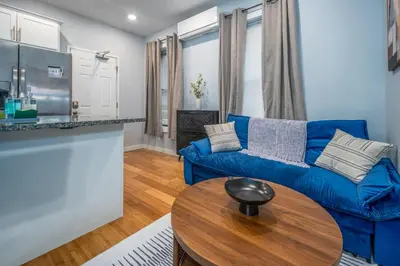 a living room with a blue couch and a table at OTR by TQL, Smart TVs, Lux King Bed, Fast Wifi, Sleeps 3ppl, 2nd Fl in Cincinnati