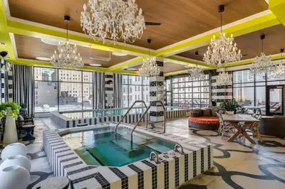 a hotel lobby with a pool and chandeliers at CBD Apartment Pool 24-7 Gym Parking in Cincinnati