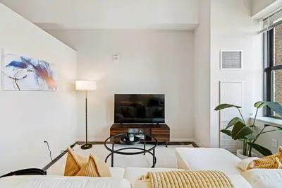 a living room with white furniture and a flat screen tv at CBD Apartment Pool 24-7 Gym Parking in Cincinnati
