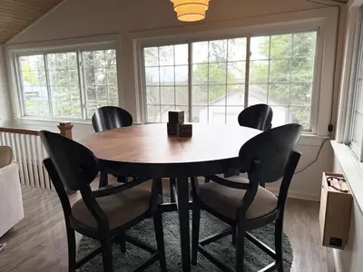 a dining room with a table and chairs and windows at New Listing The Float House at Buckeye Lake in Thornville