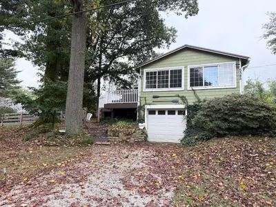 a green house with a white garage at New Listing The Float House at Buckeye Lake in Thornville