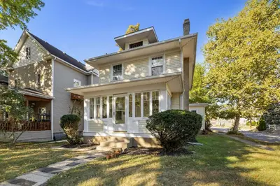 an old white house with a porch and trees at Historic 2 Bdr across from Lakeside Park in Fort Wayne