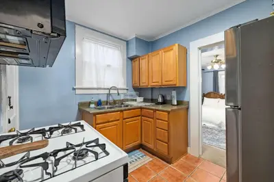 a kitchen with a stove and a sink and a refrigerator at Historic 2 Bdr across from Lakeside Park in Fort Wayne