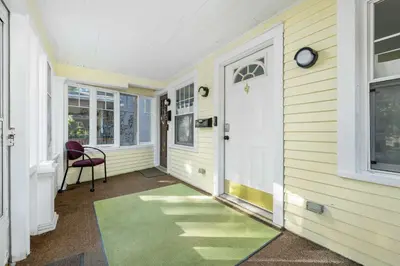 a hallway of a house with a door and a chair at Historic 1 Bdr across from Lakeside Park in Fort Wayne