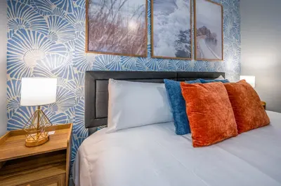 a bedroom with a bed with colorful pillows at OTR by TQL, Lux King Bed, Sleeps 4ppl, Smart TVs, Fast Wifi, 3rd Fl in Cincinnati