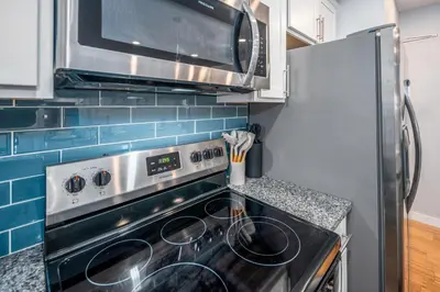 a kitchen with a stove and a microwave at OTR by TQL, Lux King Bed, Sleeps 4ppl, Smart TVs, Fast Wifi, 3rd Fl in Cincinnati