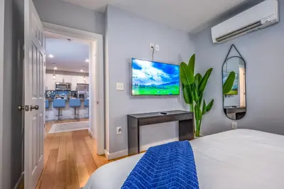 a bedroom with a bed and a tv on the wall at OTR by TQL, Lux King Bed, Sleeps 4ppl, Smart TVs, Fast Wifi, 3rd Fl in Cincinnati