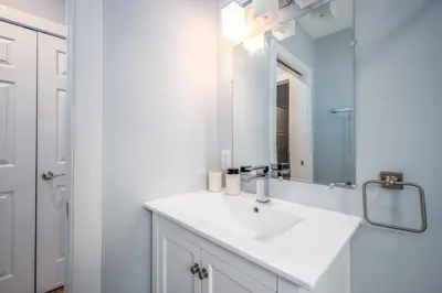 a bathroom with a white sink and a mirror at OTR by TQL, Lux King Bed, Sleeps 4ppl, Smart TVs, Fast Wifi, 3rd Fl in Cincinnati