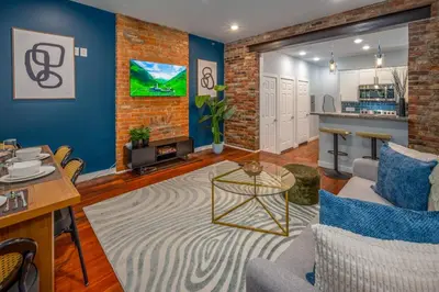 a living room with blue walls and a brick wall at OTR by Findlay, Sleeps 6ppl, King Bed, Private Balcony, 2nd Fl in Cincinnati
