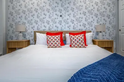 a bedroom with a white bed with red pillows at OTR by Findlay, Sleeps 6ppl, King Bed, Private Balcony, 2nd Fl in Cincinnati