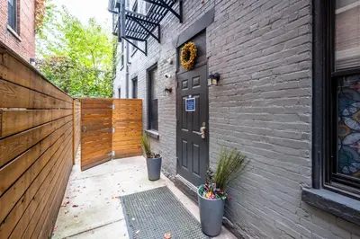 a door on a brick building with two potted plants at OTR by Findlay, Sleeps 6ppl, King Bed, Private Balcony, 2nd Fl in Cincinnati