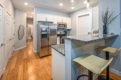 a kitchen with a stainless steel refrigerator and white cabinets at OTR by TQL, Lux King Bed, Fast Wifi, Sleeps 6ppl, 1st Fl in Cincinnati