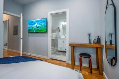 a bedroom with a bed and a bathroom with a sink at OTR by TQL, Lux King Bed, Fast Wifi, Sleeps 6ppl, 1st Fl in Cincinnati