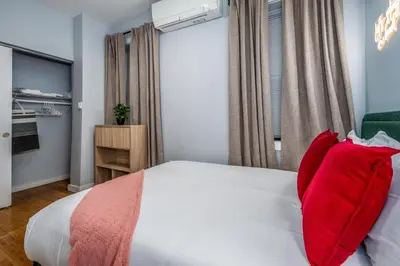 a bedroom with a white bed with red pillows at OTR by TQL, Lux King Bed, Fast Wifi, Sleeps 6ppl, 1st Fl in Cincinnati