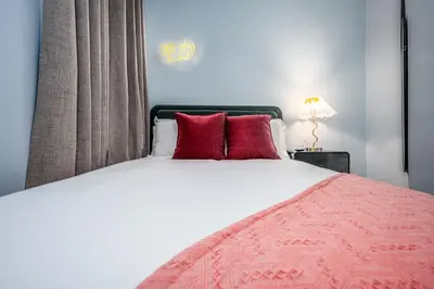 a bedroom with a large bed with red pillows at OTR by TQL, Lux King Bed, Fast Wifi, Sleeps 6ppl, 1st Fl in Cincinnati