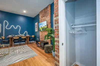 a dining room with blue walls and a brick wall at OTR by TQL, Lux King Bed, Fast Wifi, Sleeps 6ppl, 1st Fl in Cincinnati