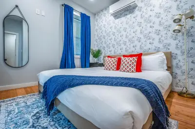 a bedroom with a large white bed with red pillows at OTR by TQL, Lux King Bed, Fast Wifi, Sleeps 6ppl, 1st Fl in Cincinnati