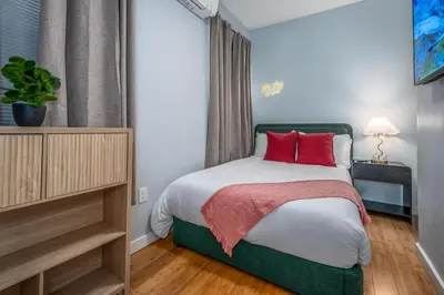 a bedroom with a bed with red pillows on it at OTR by TQL, Lux King Bed, Fast Wifi, Sleeps 6ppl, 1st Fl in Cincinnati