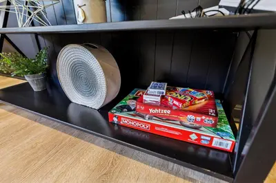 a black shelf with a fan and books on it at 2BR with Private Hot Tub in Parma Heights