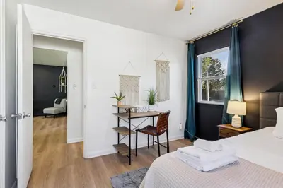 a bedroom with a bed and a table with a chair at 2BR with Private Hot Tub in Parma Heights