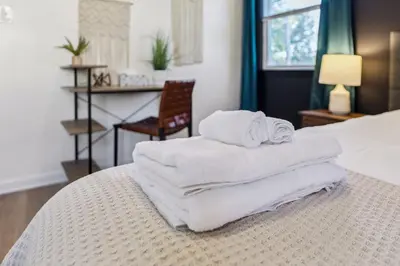 a pile of towels sitting on top of a bed at 2BR with Private Hot Tub in Parma Heights