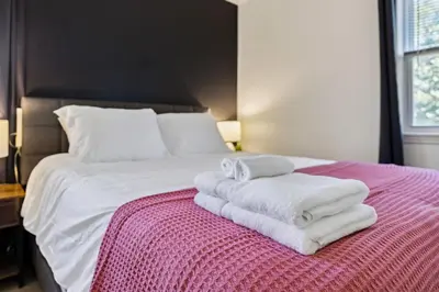 a bedroom with a bed with towels on it at 2BR with Private Hot Tub in Parma Heights