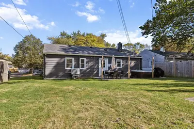 a small house sitting in a yard with a yard at 2BR with Private Hot Tub in Parma Heights