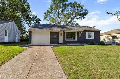 a house with a garage and a grass yard at 2BR with Private Hot Tub in Parma Heights