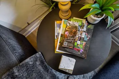 a coffee table with a magazine and aospacers at 2BR with Private Hot Tub in Parma Heights