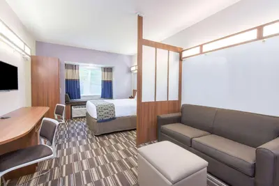 a hotel room with a bed and a couch at Microtel Inn & Suites by Wyndham Cadiz in Cadiz