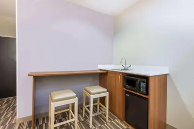 a kitchen with two stools and a counter with a sink at Microtel Inn & Suites by Wyndham Cadiz in Cadiz