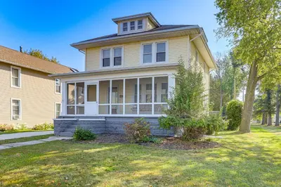 a large yellow house with a tree in the yard at Walk to Port Clinton Lighthouse Home with Deck! in Port Clinton