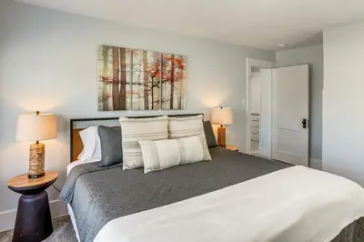a bedroom with a large white bed with two lamps at Walk to Port Clinton Lighthouse Home with Deck! in Port Clinton