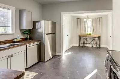 a kitchen with a stainless steel refrigerator and a table at Walk to Port Clinton Lighthouse Home with Deck! in Port Clinton