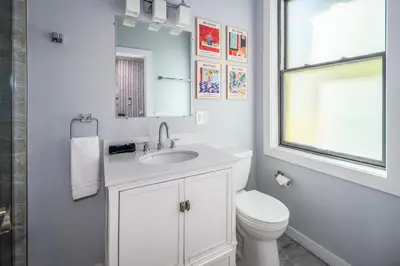 a white bathroom with a sink and a toilet at OTR by TQL, Private Rooftop, King Beds, Sleeps 8ppl, Wifi in Cincinnati