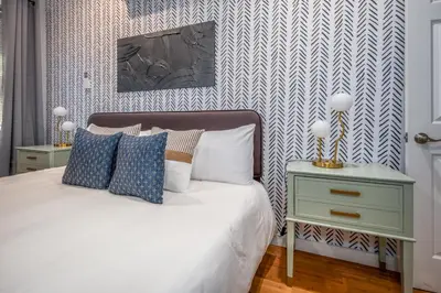 a bedroom with a bed with blue and white wallpaper at OTR by TQL, Private Rooftop, King Beds, Sleeps 8ppl, Wifi in Cincinnati