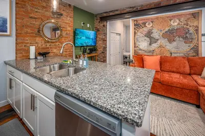 a kitchen with a sink and a couch at OTR by TQL, Private Rooftop, King Beds, Sleeps 8ppl, Wifi in Cincinnati