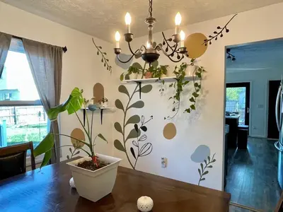 a dining room with a table with a plant on the wall at Modern Boho Retreat, in Grove City in Grove City