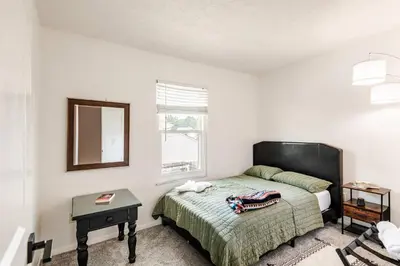 a bedroom with a bed and a mirror and a table at Modern Boho Retreat, in Grove City in Grove City