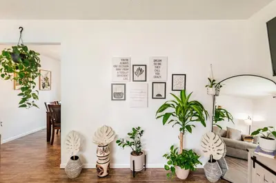 a living room with potted plants on a wall at Modern Boho Retreat, in Grove City in Grove City