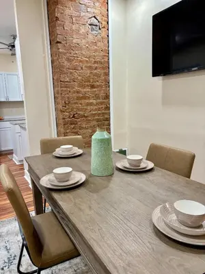 a wooden table with chairs and a green vase on it at Family Home Minutes from Downtown Cincy in Cincinnati