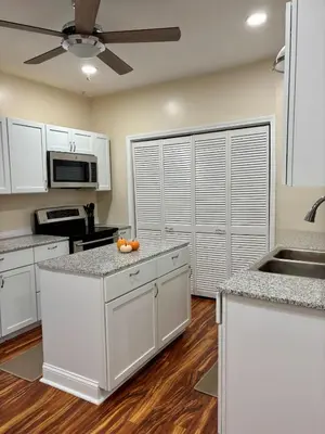 a kitchen with white cabinets and a ceiling fan at Family Home Minutes from Downtown Cincy in Cincinnati
