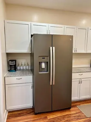 a stainless steel refrigerator in a kitchen with white cabinets at Family Home Minutes from Downtown Cincy in Cincinnati