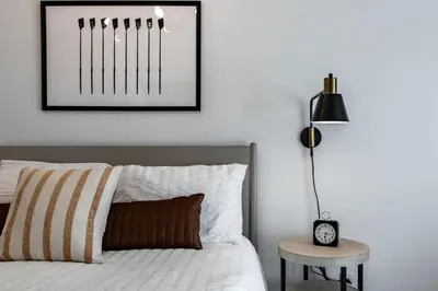 a bedroom with a bed with a black lamp and a table at Riverfront Retreat - 2 Units - 3BR - Free Parking in Cleveland
