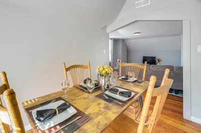 a dining room with a wooden table and chairs at Walk to Coventry Village Charming Top-Floor Unit! in Cleveland Heights