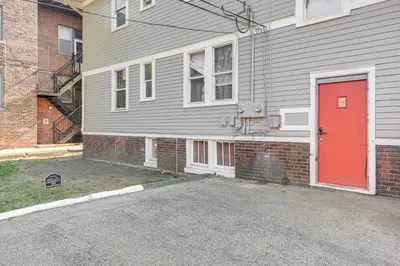a red door on the side of a house at Walk to Coventry Village Charming Top-Floor Unit! in Cleveland Heights